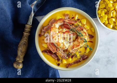 Soupe chaude à la crème de maïs épicée avec bacon et crevettes frits. Déjeuner de fruits de mer à la chowder, vue de dessus, gros plan Banque D'Images