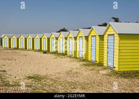 Huttes de plage colorées jaune et bleu sur le front de mer à Littlehampton, West Sussex, Angleterre. Banque D'Images