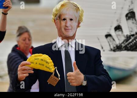 Un manifestant de la rébellion en extinction, portant un masque de Boris Johnson, tenant une manifestation textile pasty sur la plage de St Ives, pendant le sommet du G7 à Cornwall. Date de la photo: Vendredi 11 juin 2021. Banque D'Images