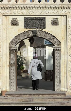 Architecture et culture en Turquie Femme avec foulard et arcades en pierre décorées à Göeme, Cappadoce Banque D'Images