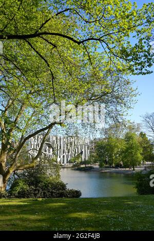 Le 'Kö-Bogen', vu à travers les branches d'arbres dans le jardin public 'Hofgarten'. Le modèle de l'architecte d'étoiles Libeskind a été conçu par le célèbre architecte New-yorkais. Banque D'Images