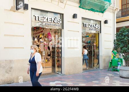 Une femme portant un masque facial comme précaution contre la propagation de covid-19 marche le long de la boutique de vêtements Tezenis. (Photo de Xisco Navarro Pardo / SOPA Images/Sipa USA) Banque D'Images