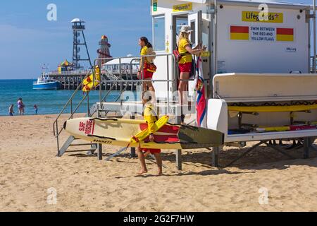 RNLI LifeGuards se prépare pour la journée lors d'une chaude journée ensoleillée à Bournemouth, Dorset UK en juin Banque D'Images