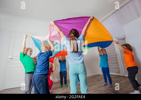 Jeux avec verrière colorée, enfants assis sous parachute Banque D'Images