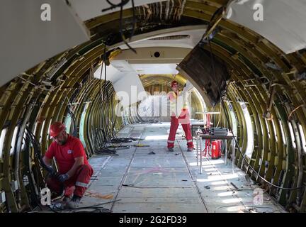 11 juin 2021, Hambourg: Les employés d'une société de démontage retirent les câbles et les panneaux dans le fuselage d'un Boeing 707-430. L'un des plus anciens avions à réaction de Lufthansa a été démantelé à Hambourg depuis vendredi. Après avoir enlevé l'intérieur, une entreprise spéciale a commencé à scier le Boeing 707-430 avec l'enregistrement D-ABOD. La maison de vente aux enchères industrielle Dechow veut vendre aux enchères autant de parties individuelles de l'avion traditionnel que possible en septembre, avec les parties d'un avion du même type qui a été démonté à Berlin-Tegel il y a quelques semaines. (À dpa, un bon enfant de 60 ans Banque D'Images