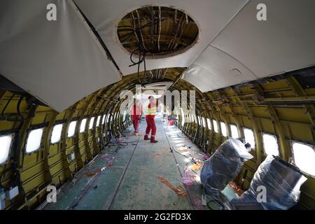 11 juin 2021, Hambourg: Les employés d'une société de démontage retirent les câbles et les panneaux dans le fuselage d'un Boeing 707-430. L'un des plus anciens avions à réaction de Lufthansa a été démantelé à Hambourg depuis vendredi. Après avoir enlevé l'intérieur, une entreprise spéciale a commencé à scier le Boeing 707-430 avec l'enregistrement D-ABOD. La maison de vente aux enchères industrielle Dechow veut vendre aux enchères autant de parties individuelles de l'avion traditionnel que possible en septembre, avec les parties d'un avion du même type qui a été démonté à Berlin-Tegel il y a quelques semaines. (À dpa, un bon enfant de 60 ans Banque D'Images