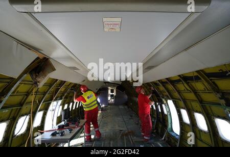 11 juin 2021, Hambourg: 'Gonflable. Life Raft' est écrit sur un panneau dans le fuselage d'un Boeing 707-430 qui est vidé par les employés d'une société de démantèlement. L'un des plus anciens avions à réaction de Lufthansa a été démantelé à Hambourg depuis vendredi. Après avoir enlevé l'intérieur, une entreprise spéciale a commencé à scier le Boeing 707-430 avec l'enregistrement D-ABOD. La maison de vente aux enchères industrielle Dechow veut vendre aux enchères autant de parties individuelles de l'avion traditionnel que possible en septembre, avec les parties d'un avion du même type qui a été démonté à Berlin-Tegel a Banque D'Images