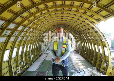 11 juin 2021, Hambourg: Jens-Peter Franz, chef de projet de la maison de vente aux enchères industrielle Dechow, se trouve dans le fuselage partiellement vidé d'un Boeing 707-430. L'un des plus anciens avions à réaction de Lufthansa a été démantelé à Hambourg depuis vendredi. Une fois l'intérieur enlevé, une entreprise spéciale a commencé à scier le Boeing 707-430 avec l'enregistrement D-ABOD. La maison de vente aux enchères industrielle Dechow veut vendre aux enchères autant de parties individuelles de l'avion traditionnel que possible en septembre, avec les parties d'un avion du même type qui a été démonté à Berlin-Tegel Banque D'Images