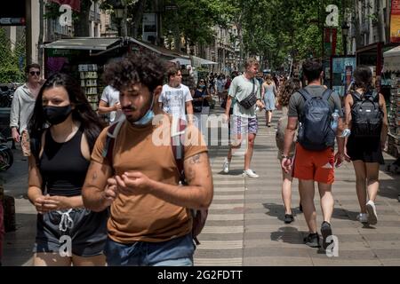 Barcelone, Espagne. 11 juin 2021. En ce vendredi matin, les gens marchent la Rambla à Barcelone où la présence de touristes parmi les locaux augmente. L'Espagne vise à stimuler l'industrie touristique qui récupère les visiteurs après plus d'un an de la pandémie du coronavirus et a commencé à émettre et à accepter les codes QR, qui permettent aux voyageurs de se déplacer librement sans avoir besoin de présenter des tests de coronavirus ni de quarantaine s'ils répondent aux critères requis. Credit: Jordi Boixareu/Alamy Live News Banque D'Images