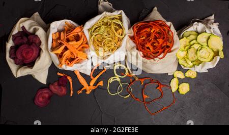 Légumes déshydratés dans des sacs textiles sur noir Banque D'Images