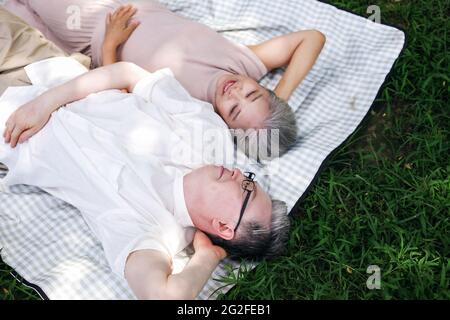 Bon vieux couple reposant sur le parc herbe photo de haute qualité Banque D'Images