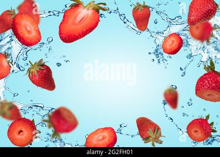 Composition créative avec des fraises mûres flottantes à léviter sur un fond bleu pastel et une éclaboussure d'eau. Vitamines, concept d'aliments frais et sains. Mi Banque D'Images