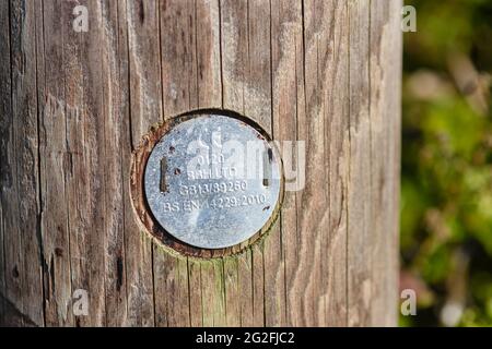 Plaque métallique avec marquage ce sur un poteau télégraphique en bois, indiquant qu'elle est conforme à la législation de l'Union européenne en matière de sécurité, de santé et de protection de l'environnement Banque D'Images