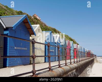 Cabanes de plage sur la promenade de la station balnéaire de Mundesley, amll North Norfolk, réputée pour sa plage de sable bleu drapeau. Banque D'Images