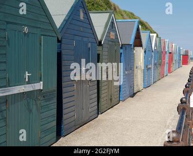 Cabanes de plage sur la promenade de la station balnéaire de Mundesley, amll North Norfolk, réputée pour sa plage de sable bleu drapeau. Banque D'Images