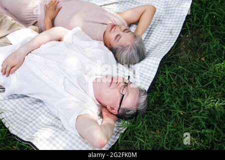 Bon vieux couple reposant sur le parc herbe photo de haute qualité Banque D'Images