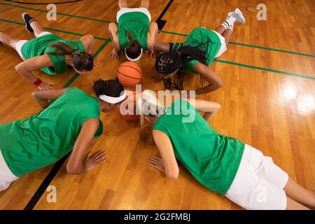 Une équipe de basket-ball féminine diversifiée portant des vêtements de sport et faisant des push-up Banque D'Images