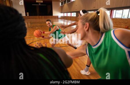 Une équipe de basket-ball féminine diversifiée portant des vêtements de sport et s'entraîner au dribbling ball Banque D'Images