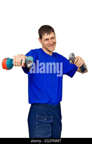 Un jeune homme joyeux avec des tournevis dans ses mains sur fond blanc. Un ouvrier aimable dans un T-shirt bleu tient un outil et sourit. Maquette Banque D'Images