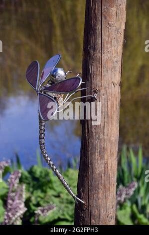 Purple Metal Dragonfly Sculpture on a Post près du lac Magnolia au Himalayan Garden & Sculpture Park, Grewelthorpe, Ripon, North Yorkshire, Royaume-Uni. Banque D'Images