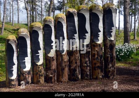 Visages parlants sur la sculpture « Logs of Dialog » au parc de sculptures et jardins de l'Himalaya, Grewelthorpe, Ripon, North Yorkshire, Angleterre, ROYAUME-UNI. Banque D'Images