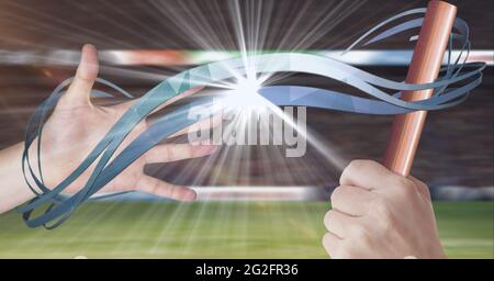 Composition des athlètes caucasiens passant le relais orange bâton avec des pistes bleues et lumière brillante Banque D'Images