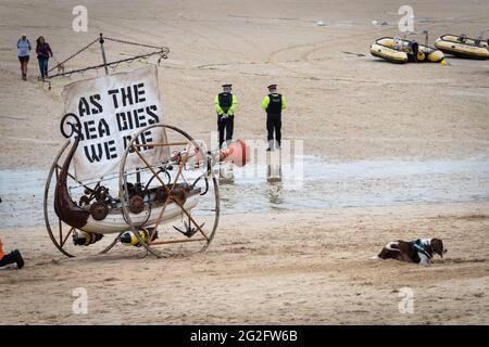 St Ives, Royaume-Uni. 11 juin 2021. La police traverse la plage de St Ives où un drapeau a été accroché dans le cadre d'une action XR. Extinction la rébellion a organisé la manifestation pour coïncider avec le Sommet du G7. L’événement voit les dirigeants mondiaux se réunir pour discuter de questions relatives au changement climatique. Credit: Andy Barton/Alay Live News Banque D'Images