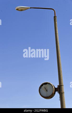 Pasewalk, Allemagne. 10 juin 2021. Une horloge abîmé sur un lampadaire sur le site d'une ancienne entreprise agricole GDR sans numéros sur le cadran. C'était le site d'une usine de mélange d'aliments concentrés de VEB Getreidewirtschaft Pasewalk jusqu'à la chute du communisme. L'horloge s'est arrêtée peu avant 11 heures. Credit: Jens Kalaene/dpa-Zentralbild/ZB/dpa/Alay Live News Banque D'Images