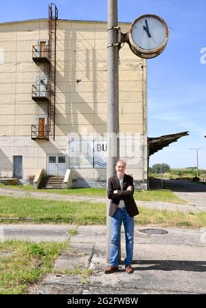 Pasewalk, Allemagne. 10 juin 2021. L'acteur Martin Brambach, en tant que Ronnie, est sur le point de filmer le film « McLenBurger - Once in a Lifetime » sur le terrain d'une ancienne ferme GDR. Dans le cadre de la comédie ARD Degeto, le plus jeune gérant de la cantine de GDR Times ouvre un restaurant avec des hamburgers faits maison et d'autres spécialités régionales. Elle est confrontée à la concurrence d'une chaîne de hamburgers dans la région. Le tournage a lieu en Mecklembourg-Poméranie occidentale et à Berlin. Credit: Jens Kalaene/dpa-Zentralbild/dpa/Alay Live News Banque D'Images