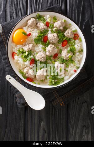 Soupe de riz thaï facile avec boulettes de viande Khao tom moo dans l'assiette sur la table. Vue verticale du dessus Banque D'Images