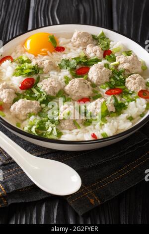 Soupe de porc et de riz thaï Khao Tom Moo SAP dans l'assiette sur la table. Verticale Banque D'Images