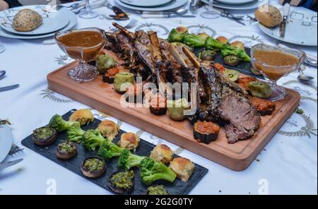 Un panier de côtes de veau barbecue avec sauce barbecue et des côtés de pommes de terre, chou-fleur et brocoli. Banque D'Images