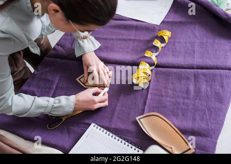 Vue en hauteur du tissu de marquage de la couture et du motif de couture de maintien près des ciseaux Banque D'Images