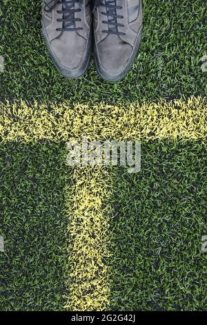 Painted markings line on all weather surface. Pair of shoes at edge of frame photograph Banque D'Images