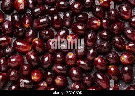 Fond de raisins rouges couverts de gouttes d'eau. Banque D'Images