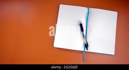 Mise au point sélective sur le livre de notes et un stylo. Le carnet de notes contient une page vide. Copier l'espace pour placer un devis ou une image sur un arrière-plan broen isolé Banque D'Images