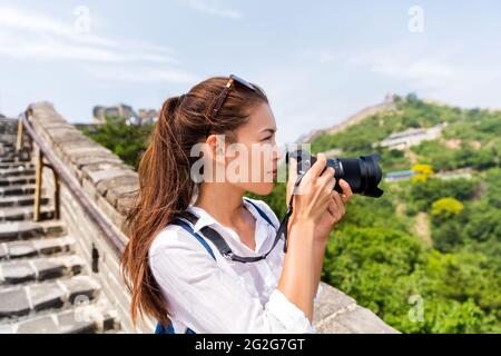 Jeune photographe asiatique prenant des photos avec un équipement photo professionnel sur la célèbre attraction chinoise la Grande Muraille. Femme amateur de photographie Banque D'Images