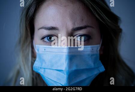 Portrait d'un médecin ou d'une infirmière triste et submergé portant un masque facial protecteur, qui a l'air épuisé déprimé et inquiet en raison de l'épidémie de coronavirus. EMO Banque D'Images