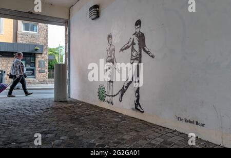 Graffiti à l'ours rebelle sur le mur de la ruelle avec une représentation conceptuelle du coronavirus Covid-19, un homme portant une balle et une chaîne, et de l'esturgeon Nicola avec coupe-boulons représentant la fin possible des restrictions de verrouillage pendant la pandémie, Canongate, Édimbourg, Écosse, Royaume-Uni Banque D'Images