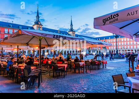 Restaurants bars et terrasses au crépuscule. La Plaza Mayor, place principale, est un grand espace public au coeur de Madrid, la capitale de l'Espagne. C'était une fois Banque D'Images