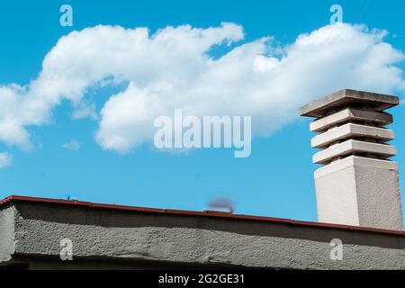 Cheminée d'une maison. Fond bleu ciel avec nuages Banque D'Images