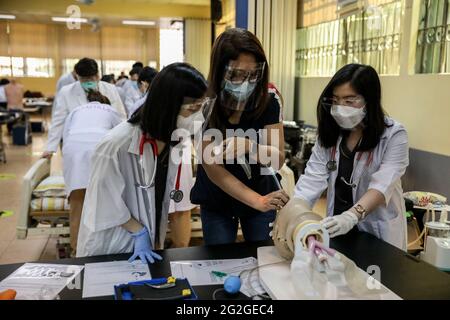 Manille, Philippines. 10 juin 2021. Les étudiants en médecine effectuent une intubation endotrachéale sur un mannequin lors d'un cours face à face à l'Université de Santo Tomas. L'université a commencé ses classes limitées en face à face après que le gouvernement a autorisé la reprise de la formation pratique et des cours de laboratoire dans les campus tout en observant les protocoles de santé pour prévenir la propagation de la maladie du coronavirus. Banque D'Images