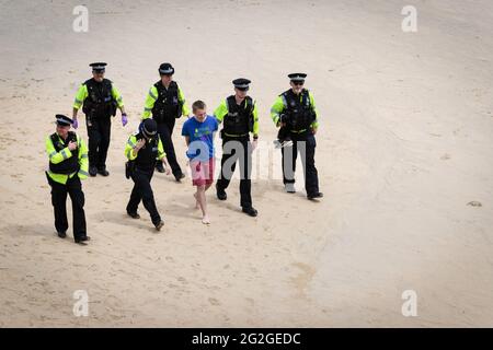 St Ives, Royaume-Uni. 11 juin 2021. Un homme est détenu par la police pendant la manifestation. Le mouvement de rébellion d'extinction descend sur la petite ville balnéaire de Cornish. Des centaines de manifestants défilent dans le village près de l'endroit où les délégués se réunissent pour le 47e G7. L’événement voit les dirigeants mondiaux se réunir pour discuter de questions relatives au changement climatique. (Photo par Andy Barton/SOPA Images/Sipa USA) crédit: SIPA USA/Alay Live News Banque D'Images