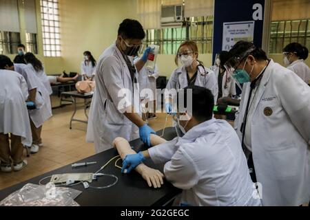 Manille, Philippines. 10 juin 2021. Les étudiants en médecine portant des blouses de laboratoire et des masques protecteurs par mesure de précaution contre la maladie du coronavirus assistent à des cours en face à face à l'Université de Santo Tomas. L'université a commencé ses classes limitées en face à face après que le gouvernement a autorisé la reprise de la formation pratique et des cours de laboratoire dans les campus tout en observant les protocoles de santé pour prévenir la propagation de la maladie du coronavirus. Banque D'Images