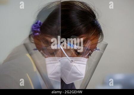 Manille, Philippines. 10 juin 2021. Un étudiant en médecine se reflète sur une barrière plastique lors d'une classe face à face à l'Université de Santo Tomas. L'université a commencé ses classes limitées en face à face après que le gouvernement a autorisé la reprise de la formation pratique et des cours de laboratoire dans les campus tout en observant les protocoles de santé pour prévenir la propagation de la maladie du coronavirus. Banque D'Images