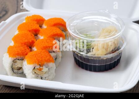 petits pains à sushis avec saumon et caviar dans des plats thermiques jetables pour livraison. Banque D'Images