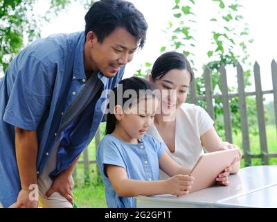 La famille heureuse de trois utilise une tablette informatique en extérieur photo de haute qualité Banque D'Images