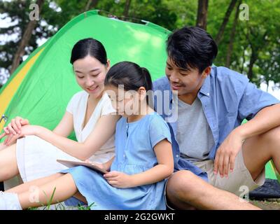 La famille heureuse de trois utilise une tablette informatique en extérieur photo de haute qualité Banque D'Images