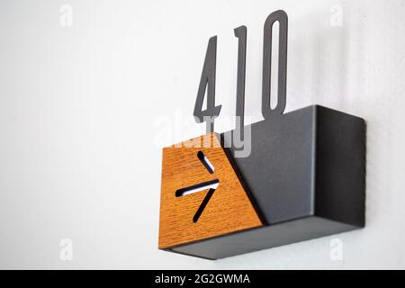 Gros plan d'un panneau noir et en bois sur le mur avec un numéro 410 Banque D'Images