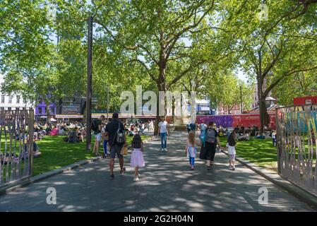 Les gens dehors et autour et se détendre sur une chaude, ensoleillé, jour d'été à Leicester Square. Londres, Angleterre, Royaume-Uni Banque D'Images